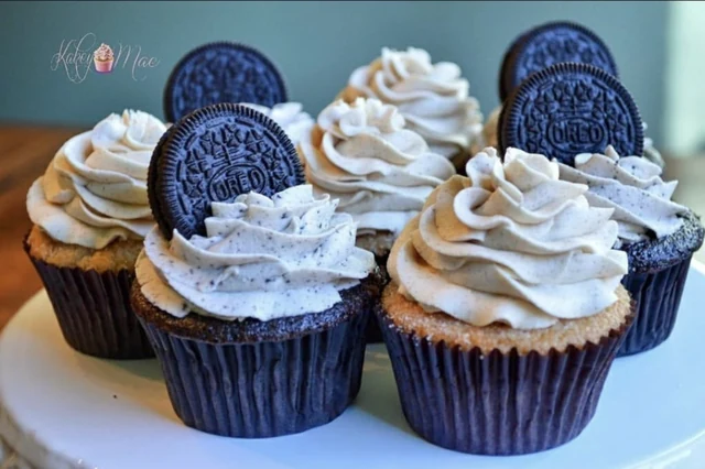 Cookie-topped cupcake collection by Kakey Mae. Chocolate sandwich cookies standing in generous white frosting swirls.