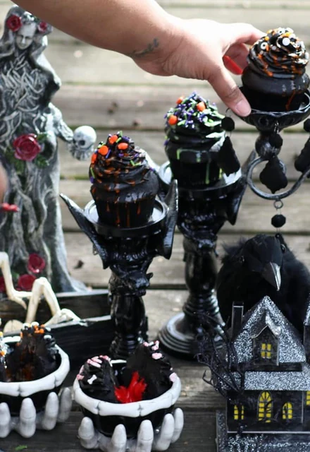 Halloween party cupcakes by Kakey Mae. Dark buttercream cupcakes in a Halloween display with skeleton and haunted-house decorations.