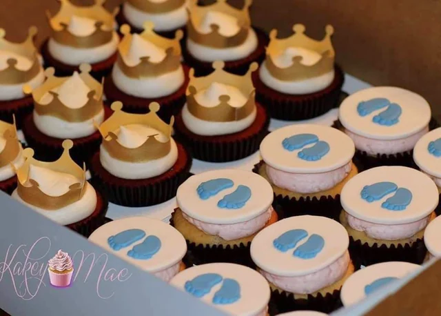 Little crowns & tiny footprints by Kakey Mae. Gold crown-shaped toppers and blue footprints on coordinated cupcakes.