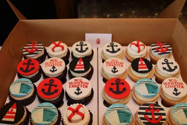 Nautical party cupcakes by Kakey Mae. Sailboats, anchors, life rings, and striped toppers in red, white, and blue.