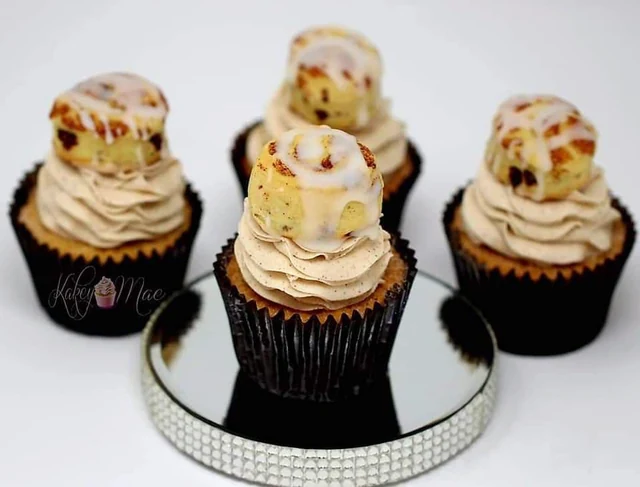 Mini cake toppers by Kakey Mae. Miniature tiered cake shapes in cream and gold atop buttercream cupcakes.