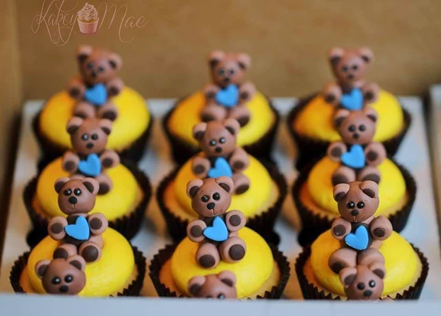 Teddy bear cupcakes by Kakey Mae. Little brown bears with blue bows on bright yellow cupcake tops.